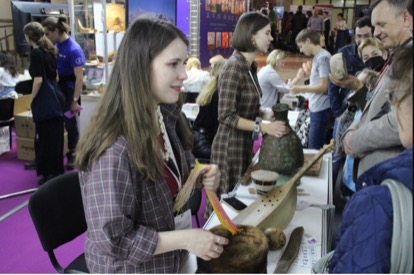 Екатерина Панина и Александра Савченко рассказывают посетителям выставки про музыкальные инструменты и предметы быта